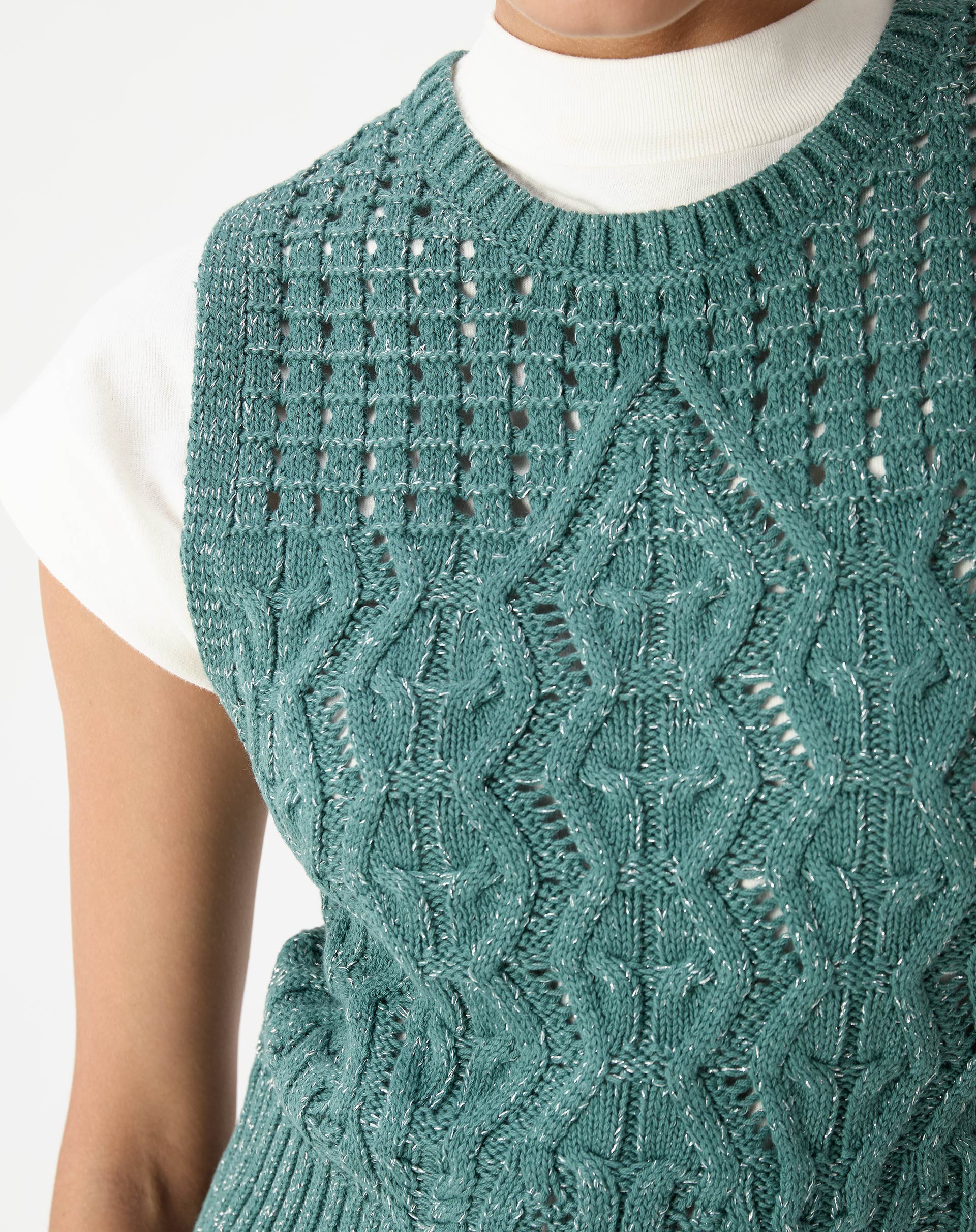 Close da frente da regata tricot verde evidenciando ponto diferenciado com tranças e pequenos vazados