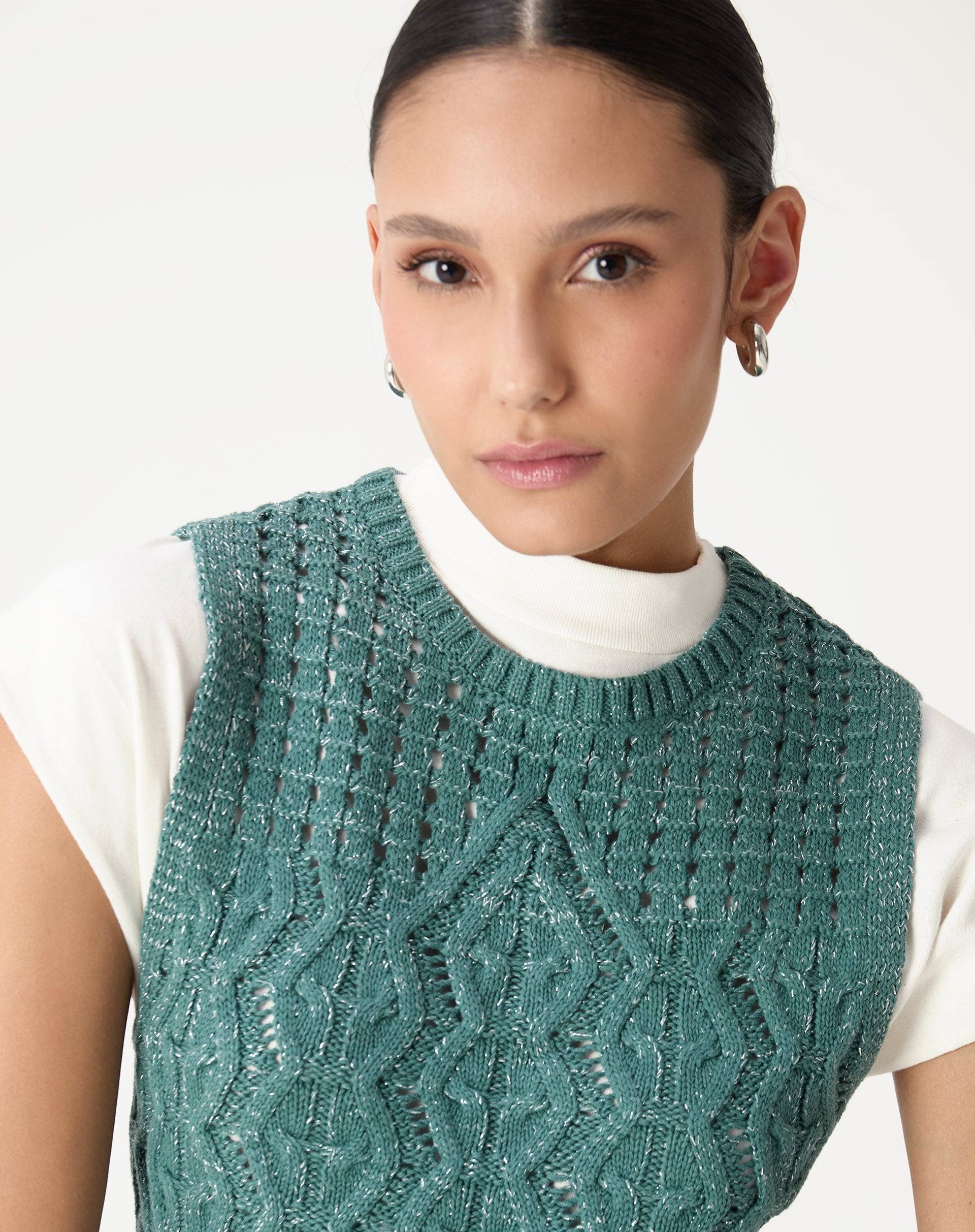 Detalhe do decote redondo e cava da regata tricot verde com acabamento canelado e textura do fio