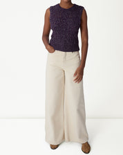 Vista traseira da regata tricot roxa em modelo, destacando o ponto vazado e o decote redondo.