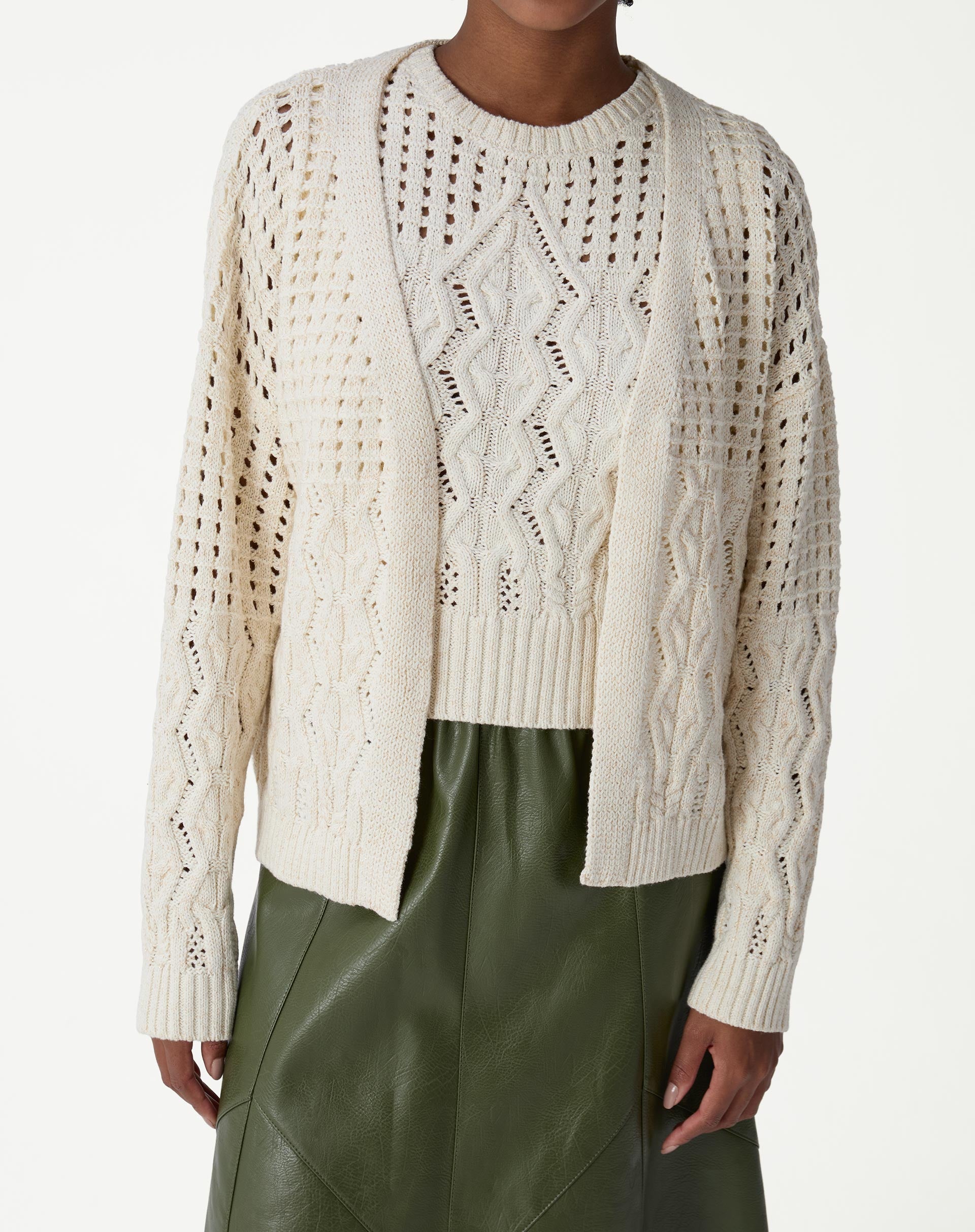 Modelo vestindo um cardigan de tricô bege com ponto diferenciado, visual de frente com saia midi verde - cardigan aberto e manga longa