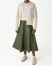 Pormenor da finalização frontal do cardigan de tricô bege com barra canelada e textura em tranças