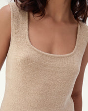 Regata tricot bege vista plana (flat lay) evidenciando comprimento longo e corte reto com acabamento clean.