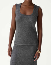 Detalhe frontal do corpo usando a regata tricot chumbo, acabamento da barra e caimento