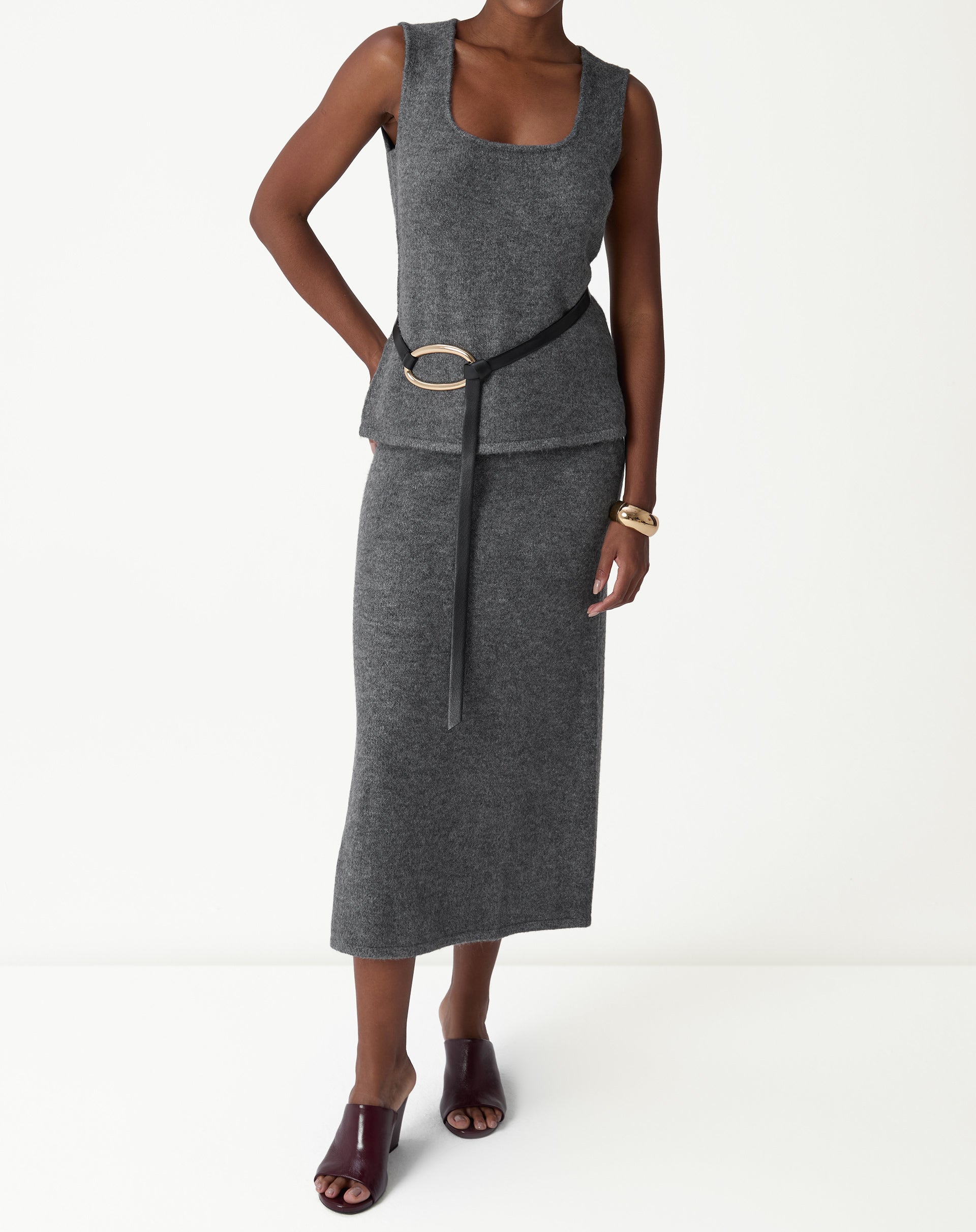 Regata tricot chumbo em look com cinto marcado na cintura e saia longa, visual de corpo inteiro