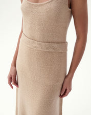 Saia longa tricot bege vista lateral em modelo mostrando o caimento e a barra levemente solta