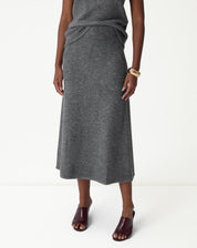 Detalhe frontal da saia longa tricot chumbo destacando o cós alto canelado e o caimento da malha.