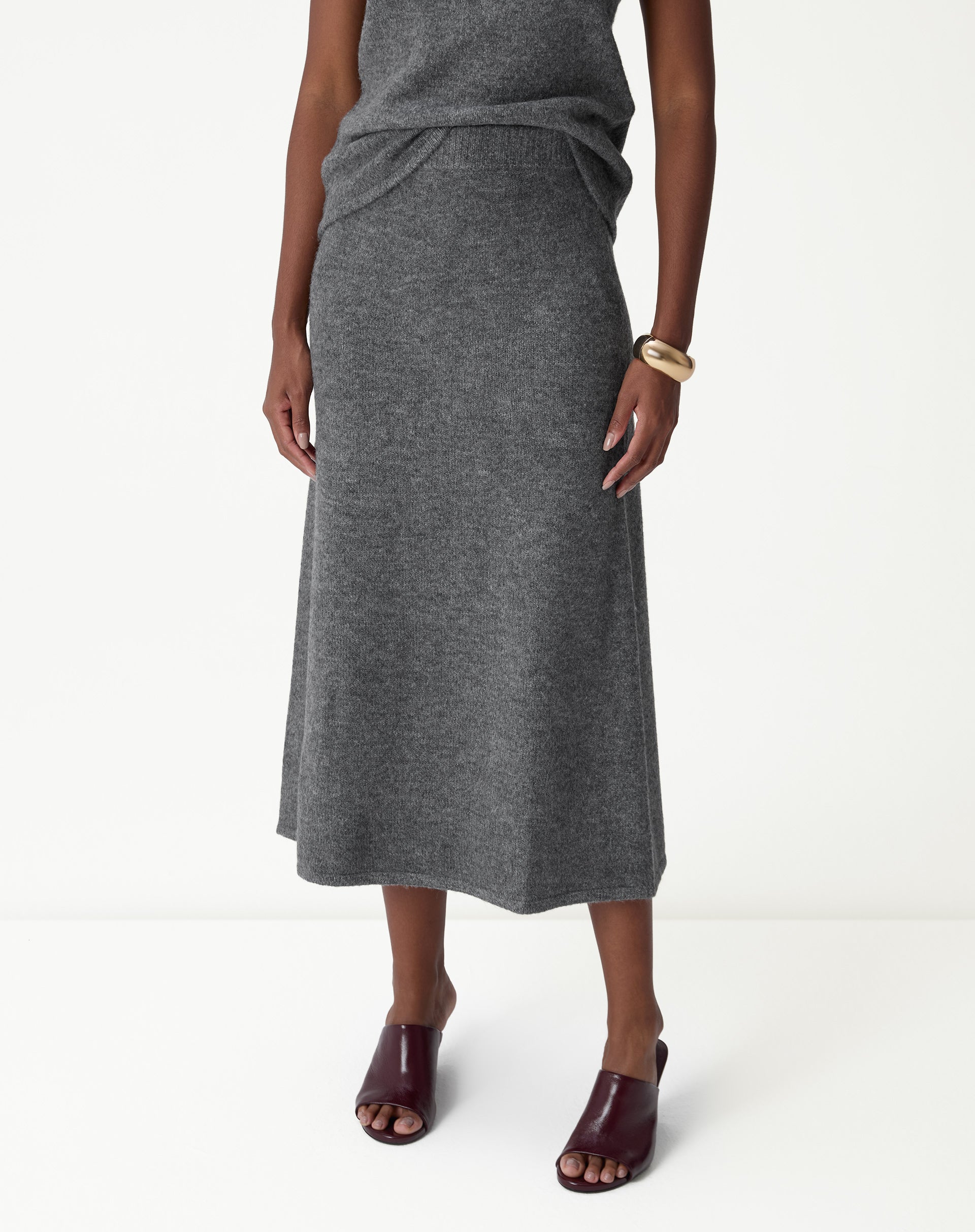 Detalhe frontal da saia longa tricot chumbo destacando o cós alto canelado e o caimento da malha.