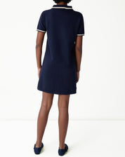 Rear view of navy blue polo knit dress modeled, showing smooth back, straight cut and flat hemline