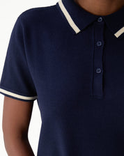 Close-up of the shoulder and sleeve of navy blue polo knit dress with cream contrasting stripe at sleeve hem