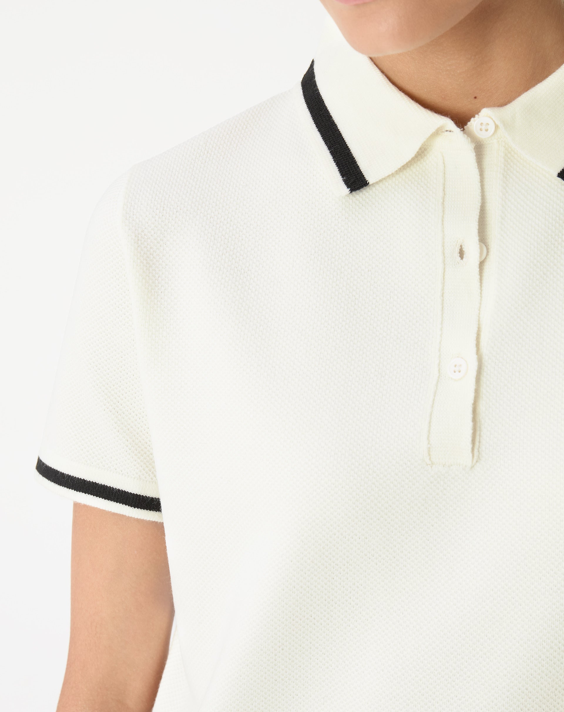 Detalhe do ombro e da gola do vestido polo tricot off-white com filete preto, mostrando trama e acabamento