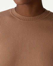 Conjunto completo: suéter de tricô bege sob blazer preto e saia midi preta, estilo casual de escritório com mocassins.