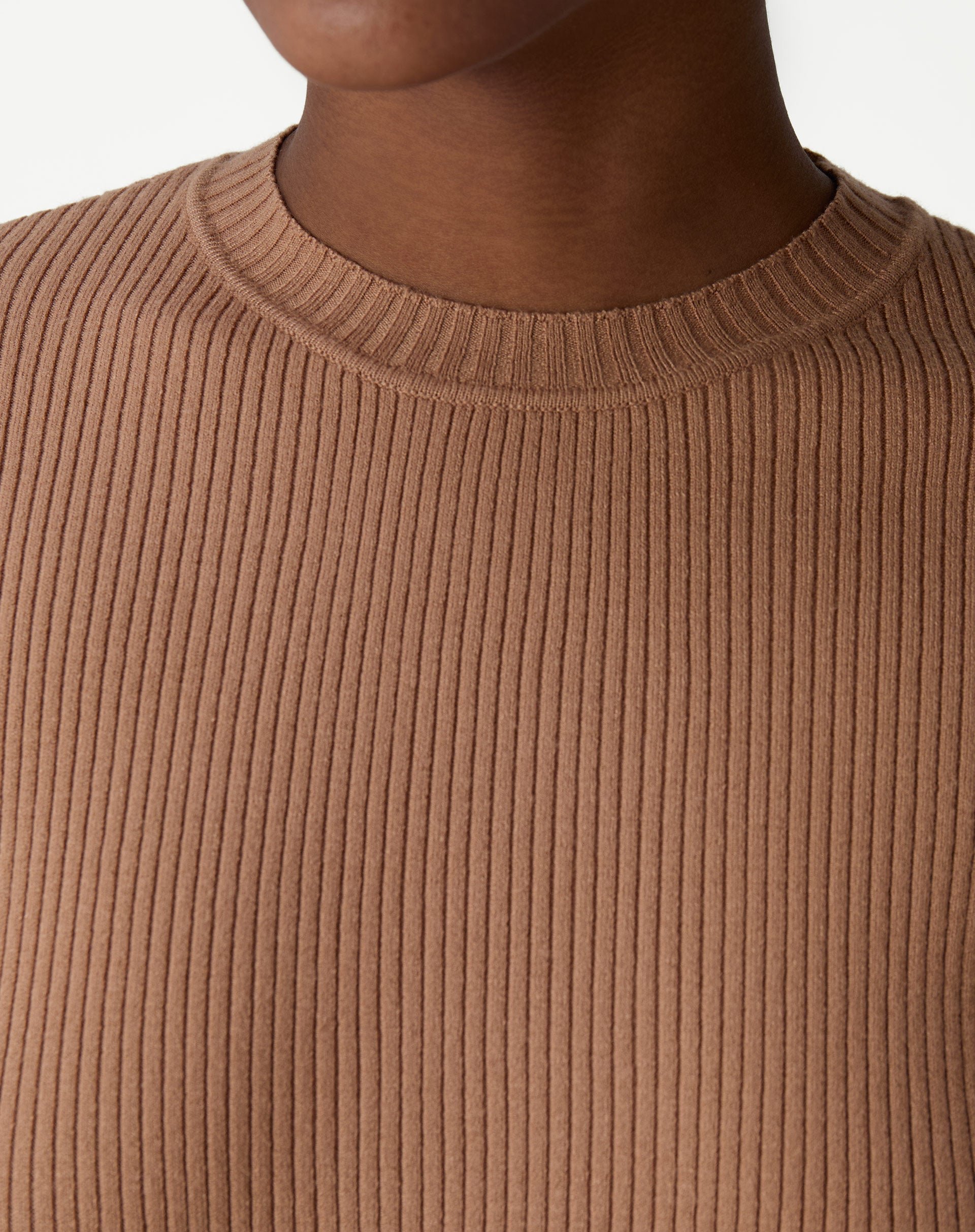 Conjunto completo: suéter de tricô bege sob blazer preto e saia midi preta, estilo casual de escritório com mocassins.