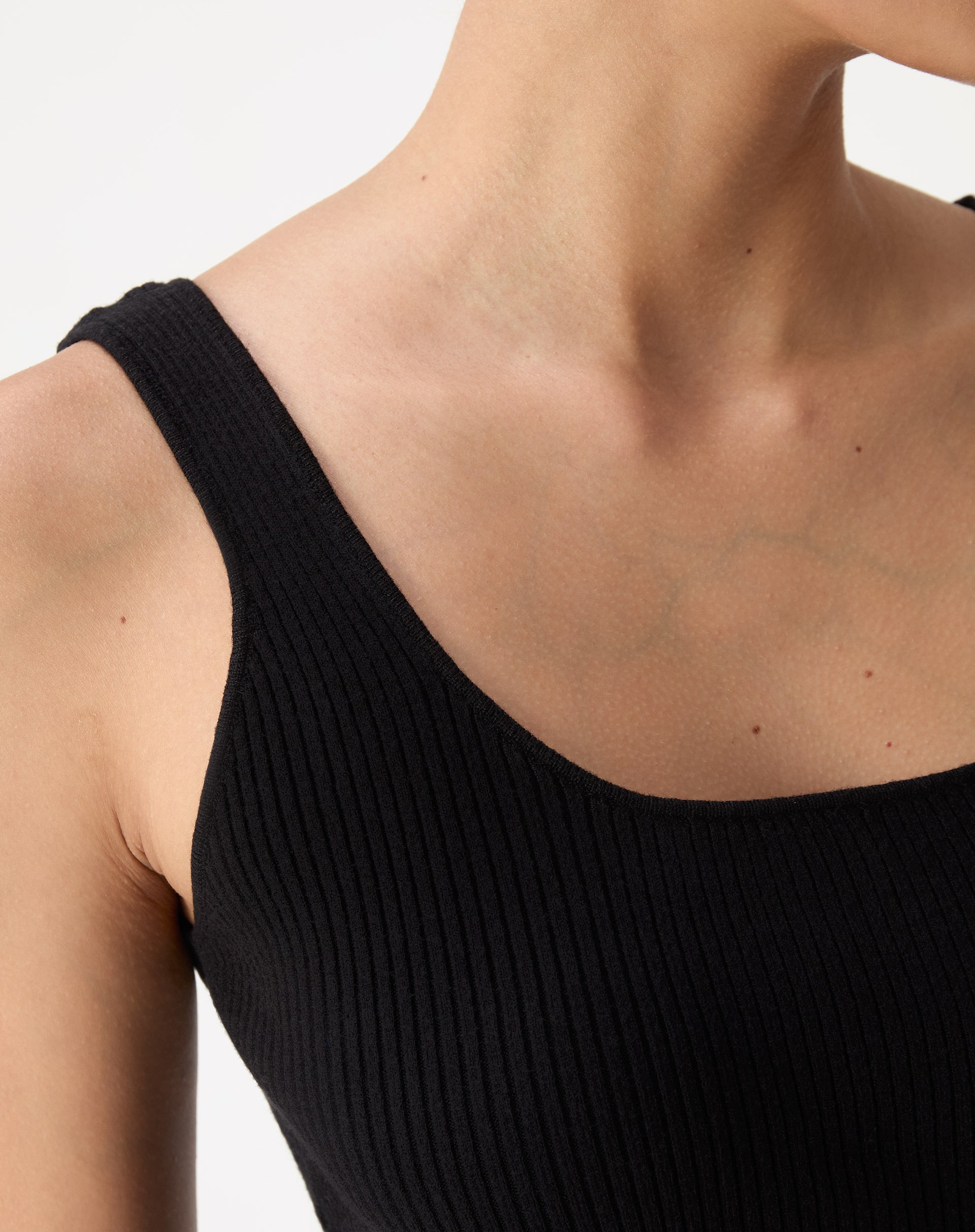 Regata tricot preta vista frontal em fundo branco, corte midi e barra reta