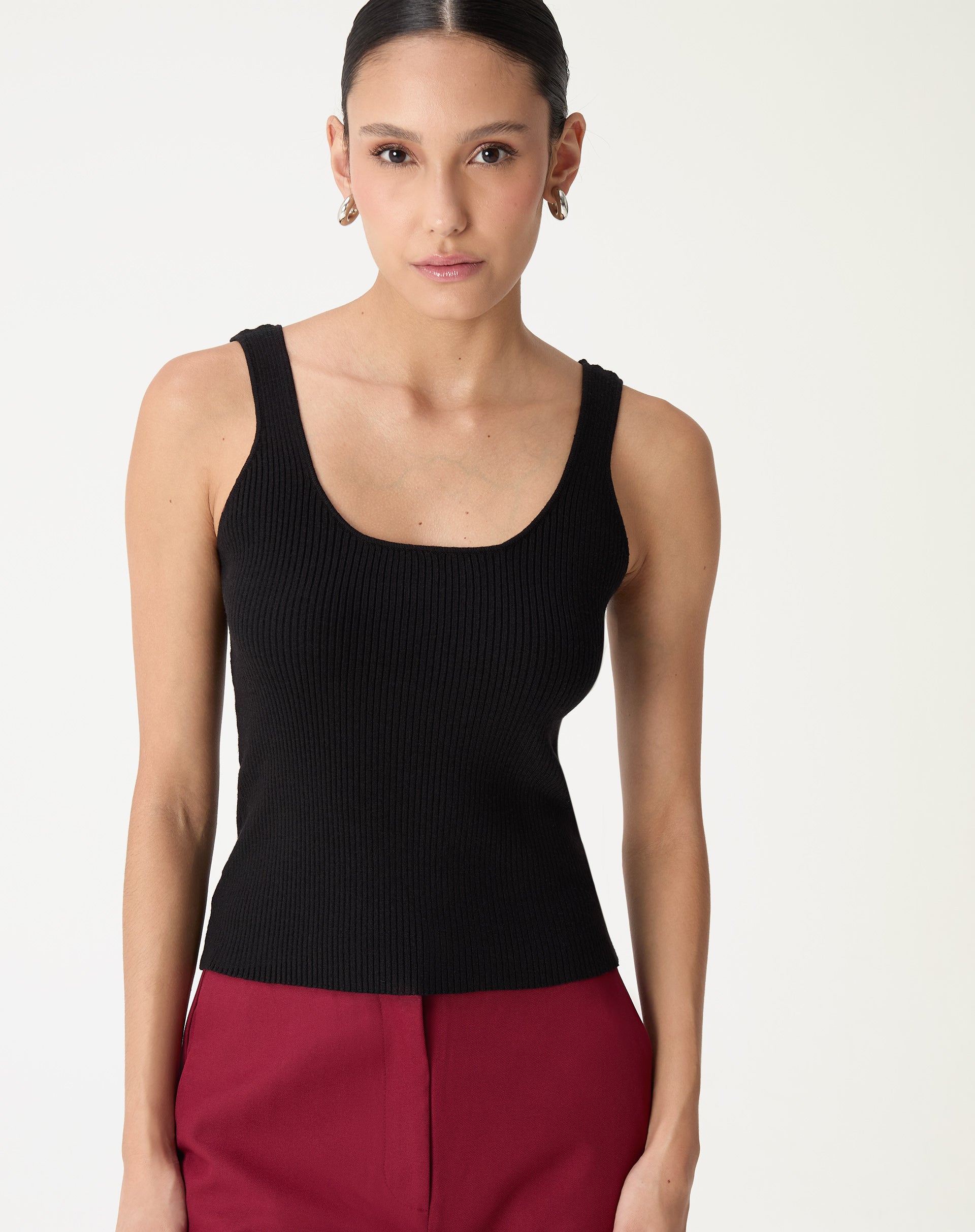 Regata básica tricot preta decote U vista frontal em modelo, caimento ajustado e comprimento midi