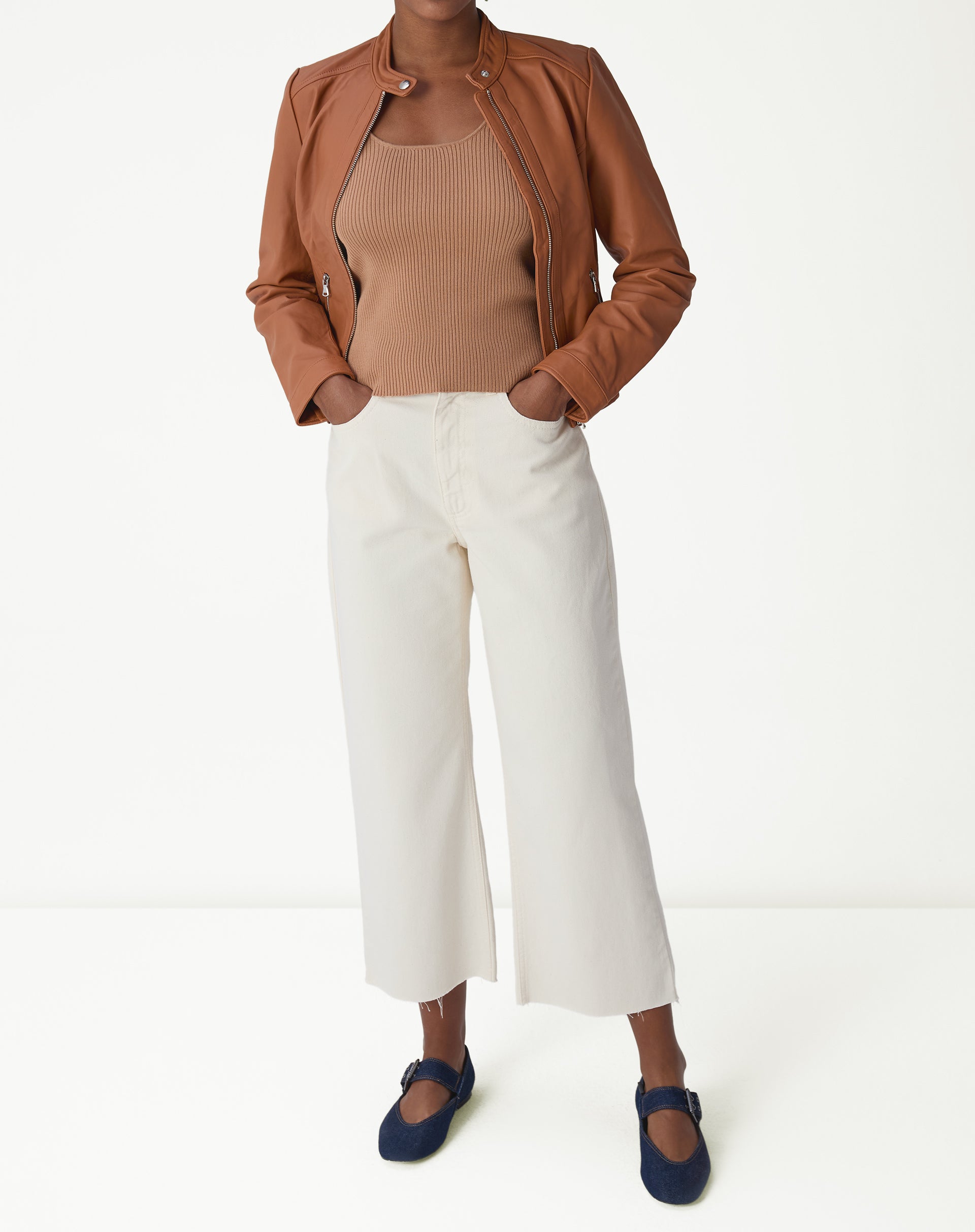 Close-up do decote U e textura canelada da regata básica tricô bege mostrando acabamento da alça