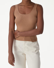 Modelo vestindo regata básica tricô decote U bege vista frontal, alças largas e textura canelada