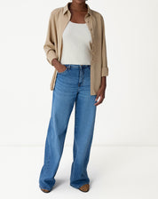 Regata tricot off-white vista traseira em modelo, mostrando decote U nas costas e barra reta.