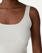 Close-up lateral da regata tricot off-white em fundo branco, mostrando caimento e acabamento das alças.