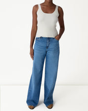 Look com regata tricot off-white usada sob camisa overshirt bege e calça jeans wide-leg - styling casual.