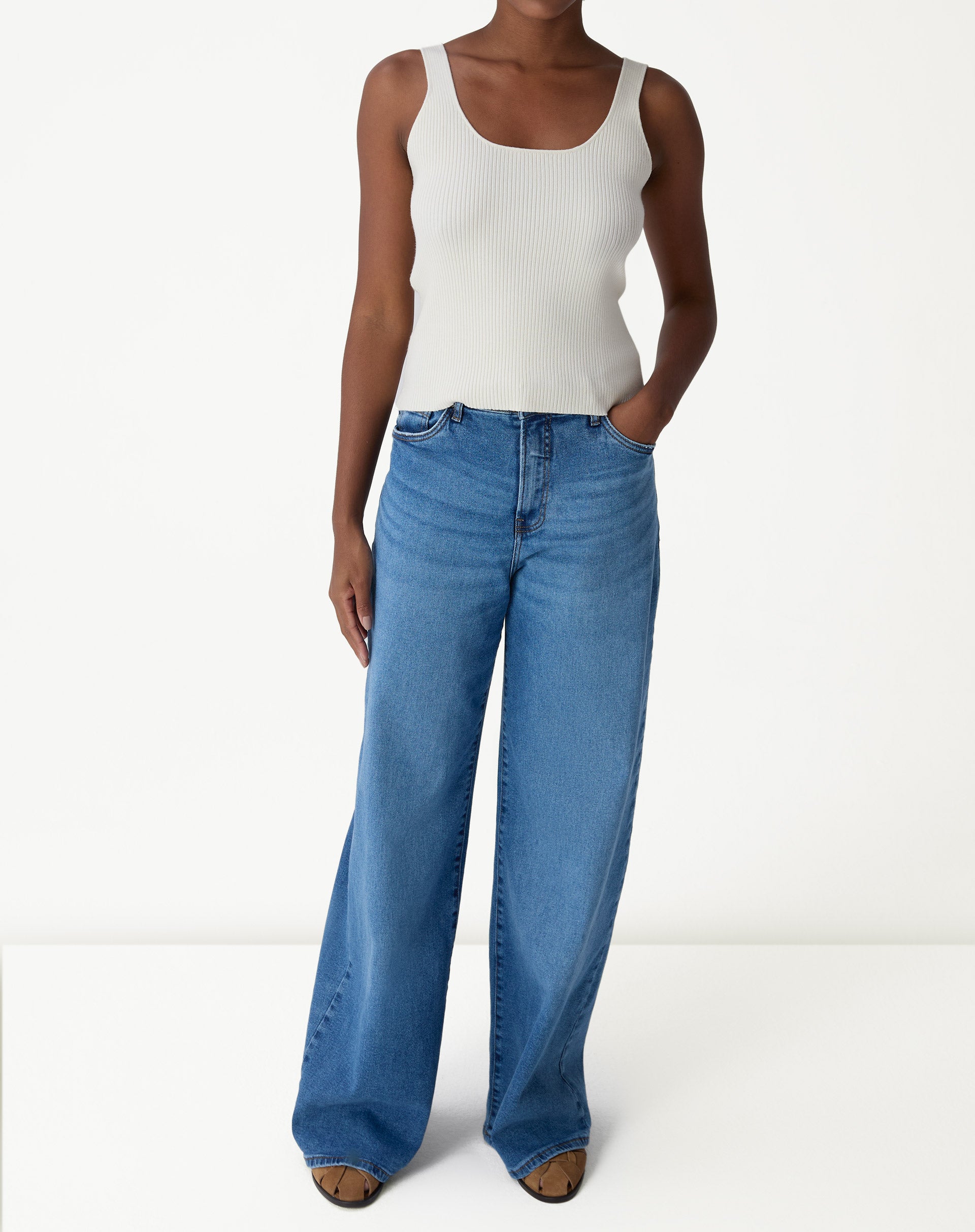 Look com regata tricot off-white usada sob camisa overshirt bege e calça jeans wide-leg - styling casual.