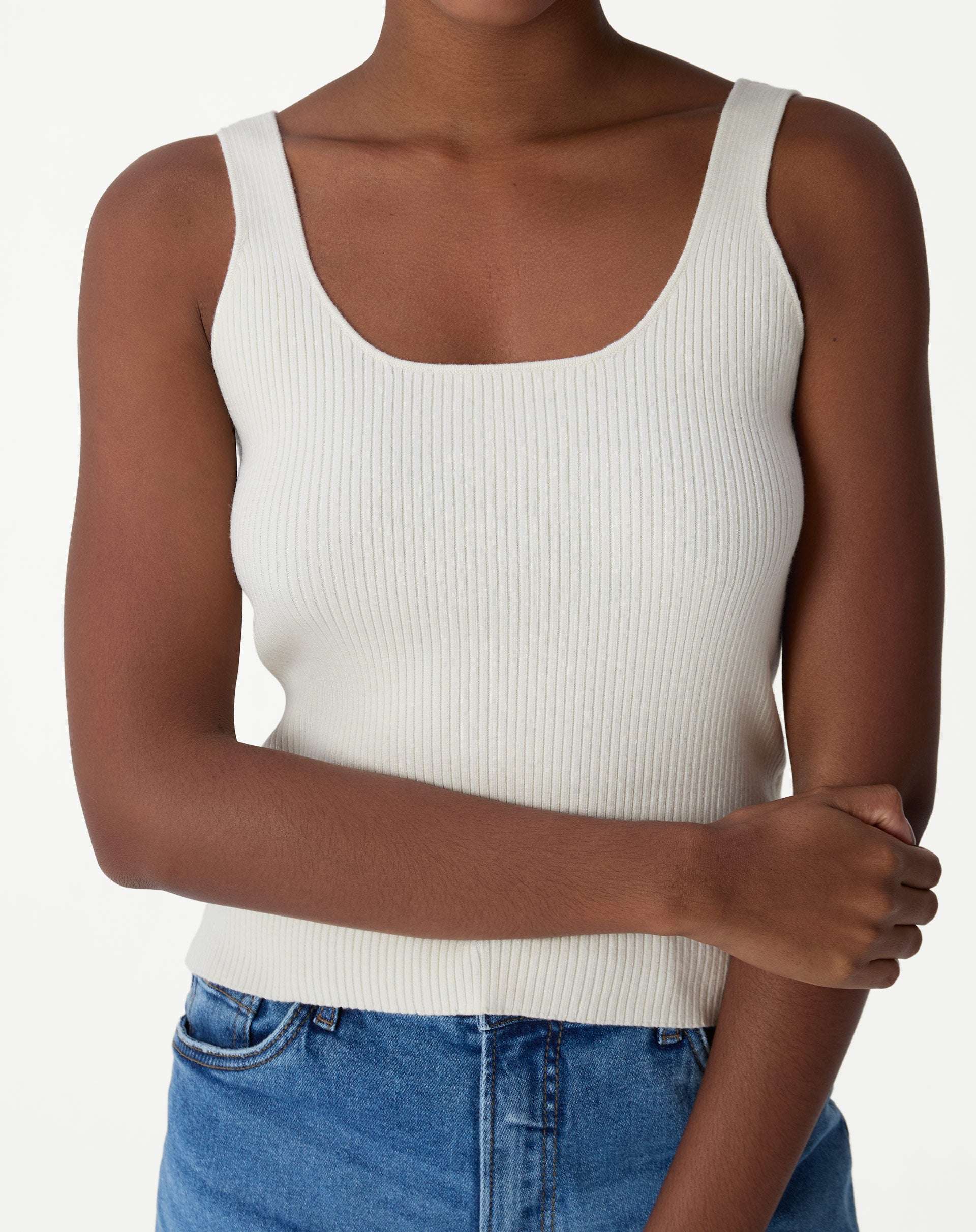 Regata tricot canelado off-white vista frontal em close-up, decote U e alças largas em modelo.