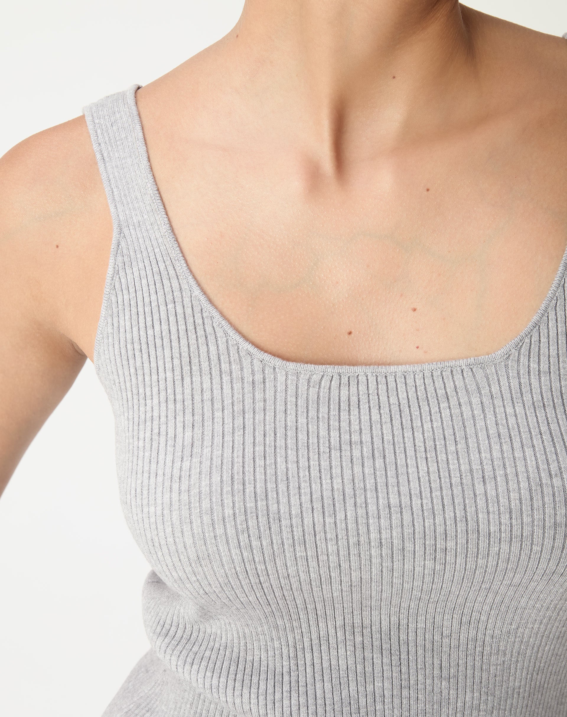 Close no decote U e na textura canelada da regata tricot cinza mescla mostrando acabamento e malha