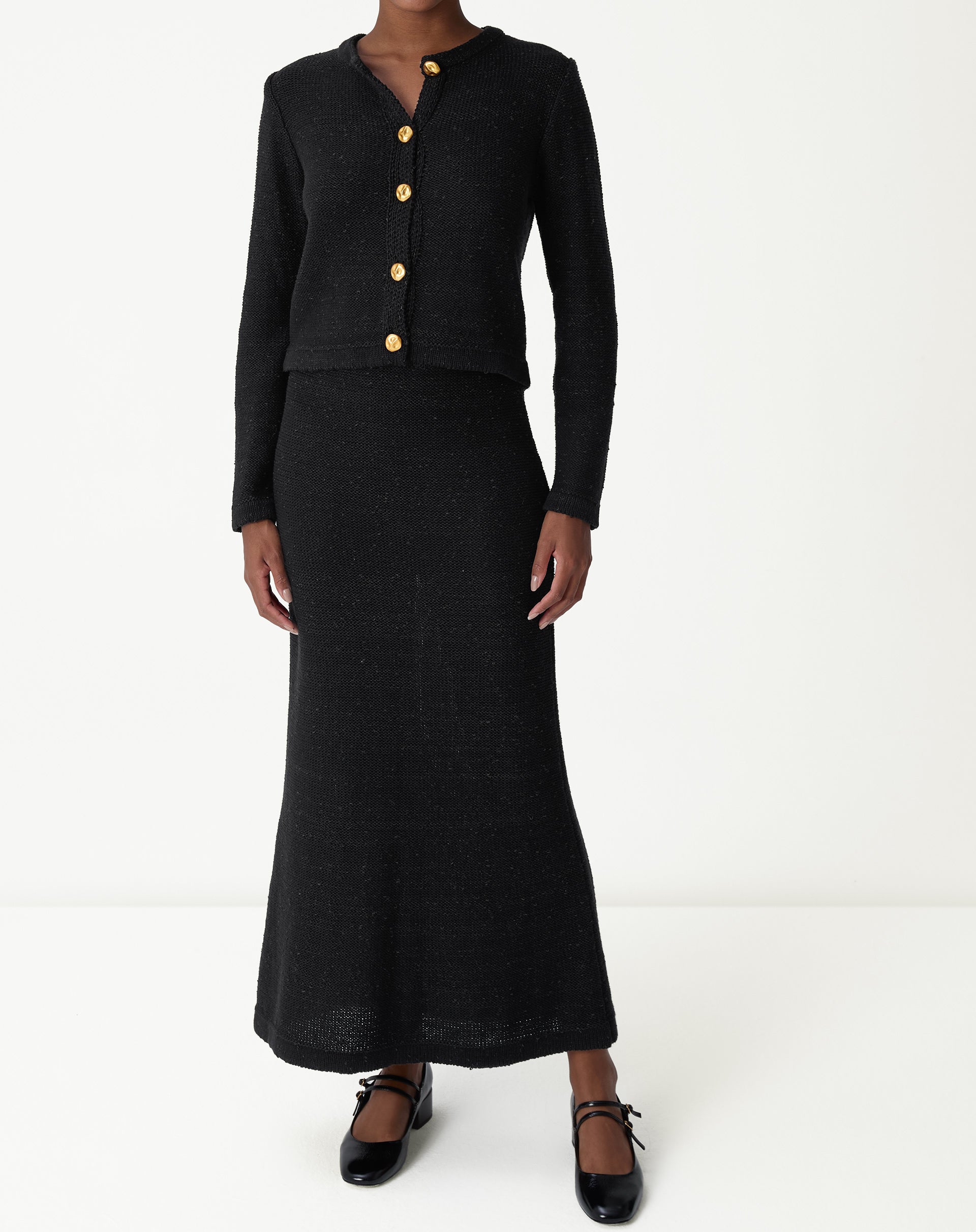 Saia longa tricot preta vista frontal em modelo: cós alto, caimento slim e comprimento maxi, imagem completa do look