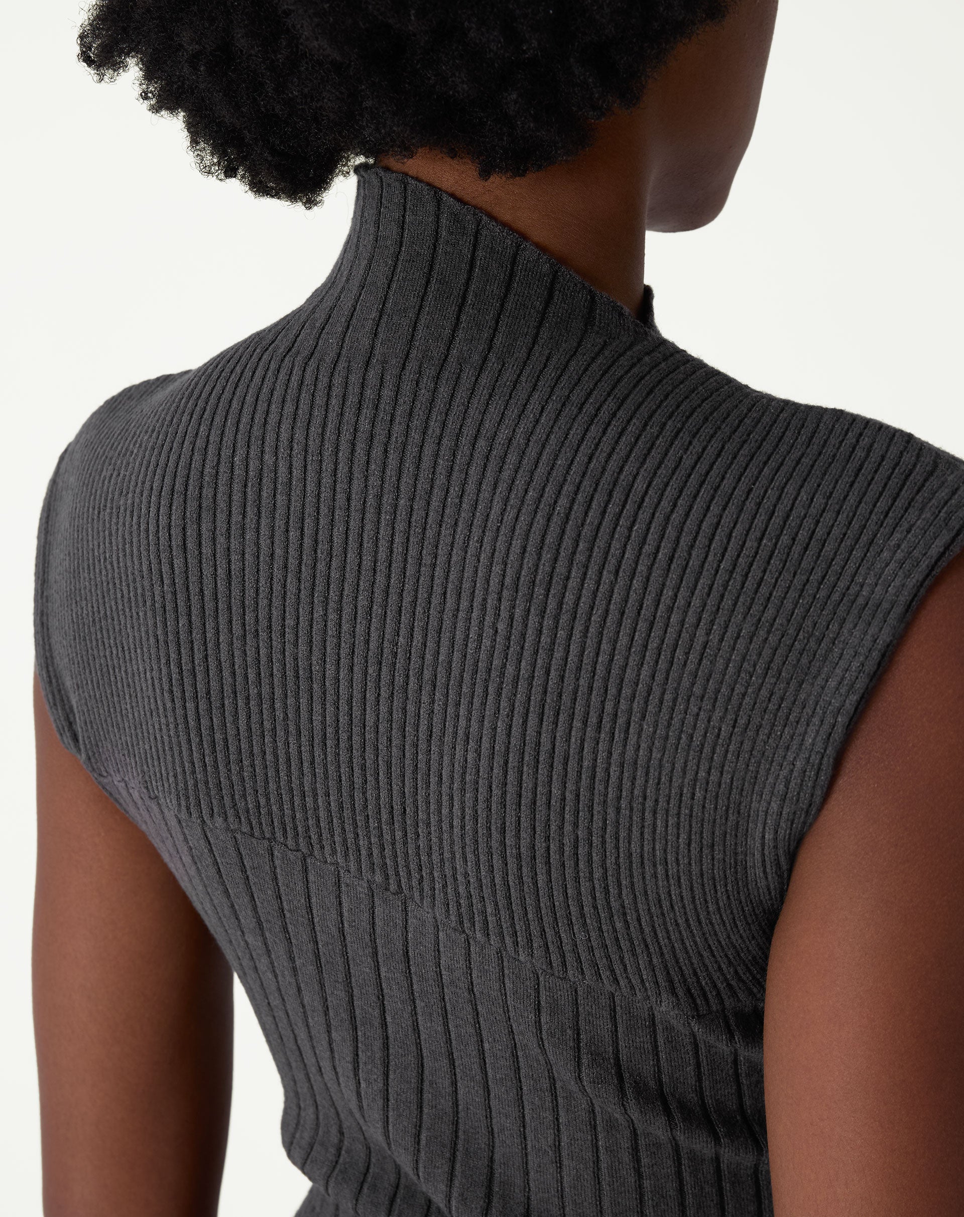 Close-up da parte superior traseira e ombro do vestido canelado em tricot, acabamento sem manga e textura uniforme