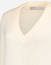 Detail of the collar with AMARO tag and inside the V-neckline of off-white knit dress showing finish and fabric composition