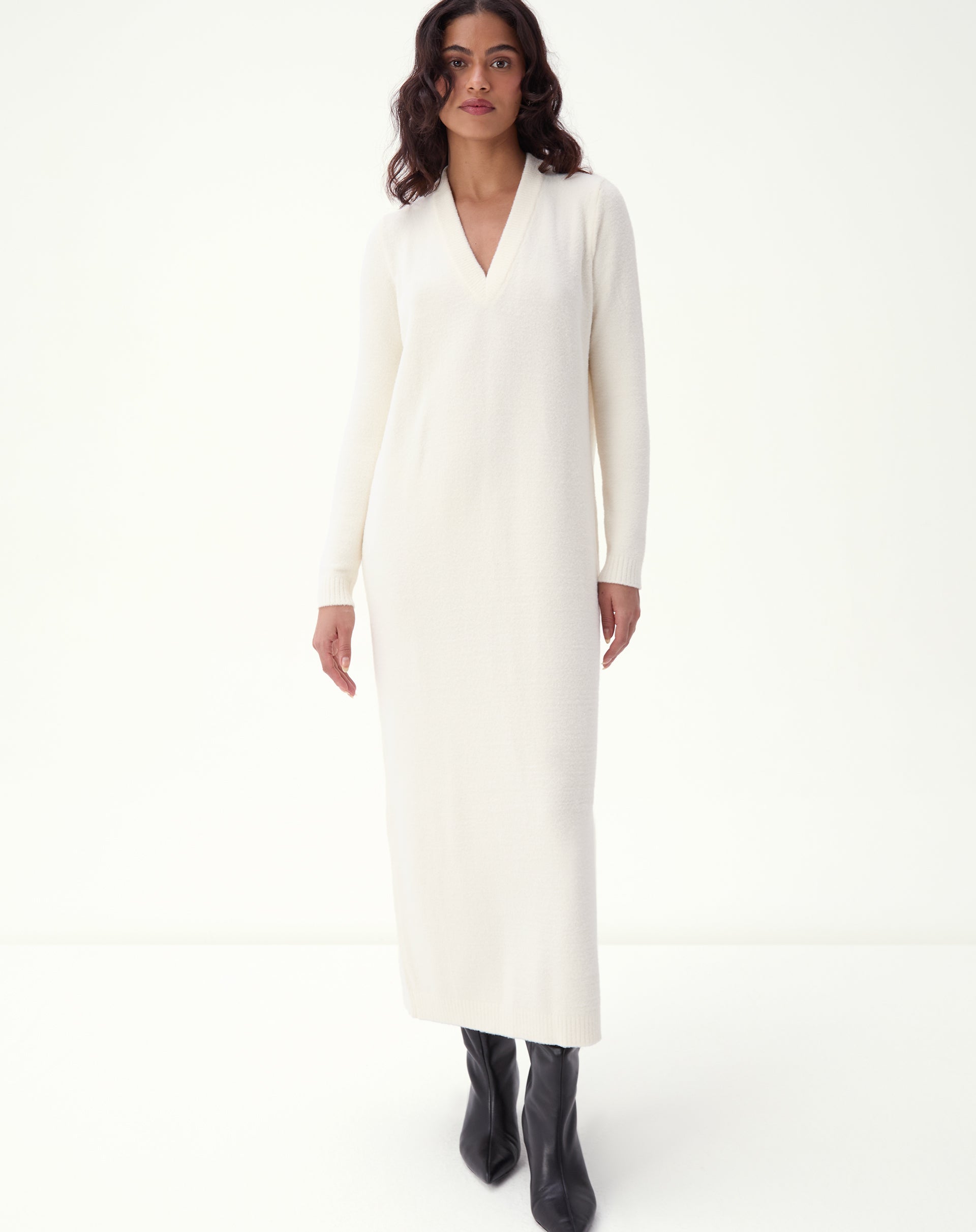 Midi dress in off-white knit front view in studio: model with V-neckline, long sleeves, and straight fit, minimalist look with black boots - off-white midi knit dress