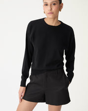 Suéter gola careca de cashmere preto em modelo frontal, caimento loose e manga longa, detalhe barra canelada