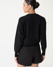 Vista posterior do suéter gola careca em cashmere preto mostrando corte reto e comprimento até o quadril