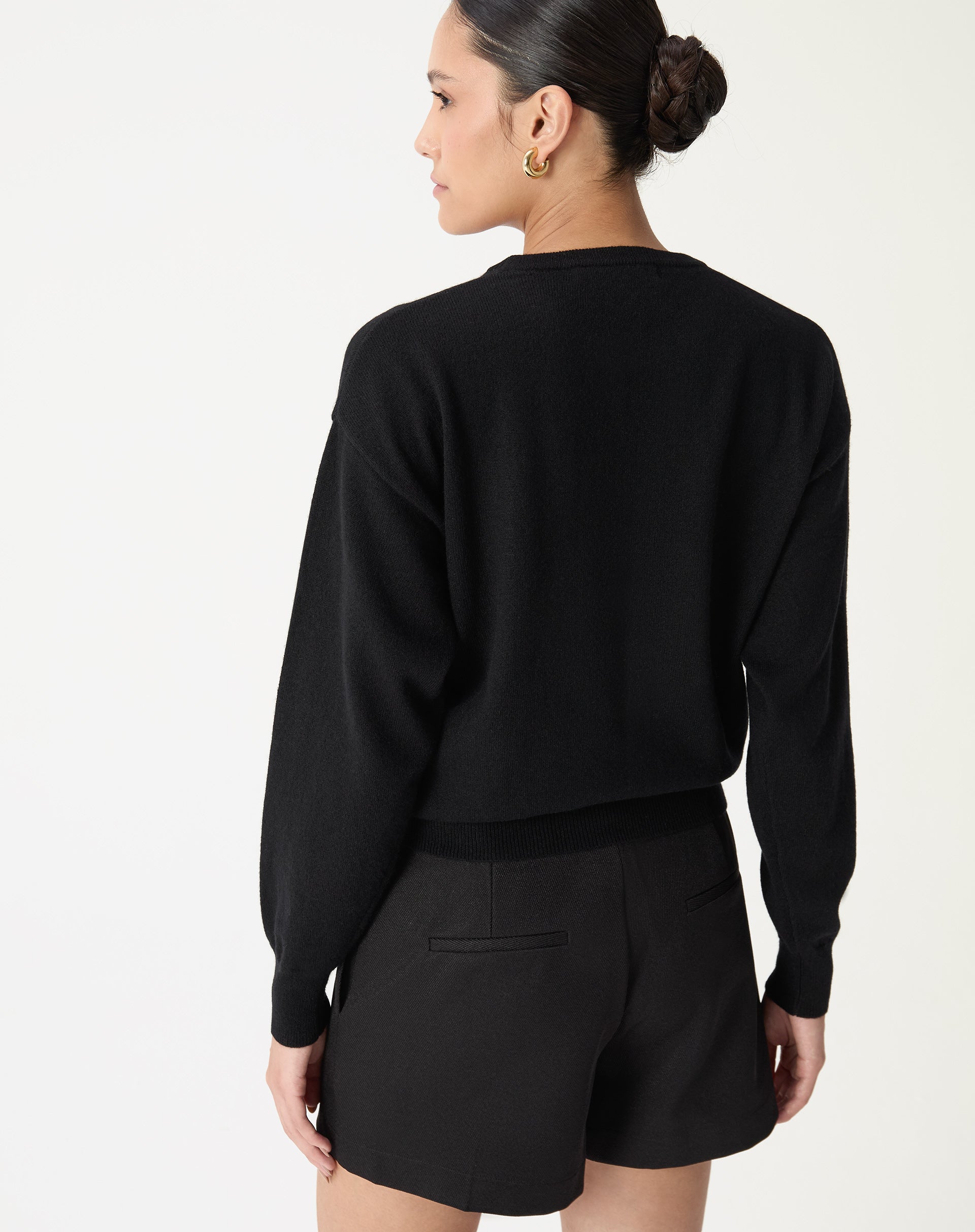 Vista posterior do suéter gola careca em cashmere preto mostrando corte reto e comprimento até o quadril