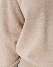 Visual completo com suéter de gola careca em cashmere cáqui, jaqueta curta bege, calças jeans retas e botas — estilo casual sofisticado.