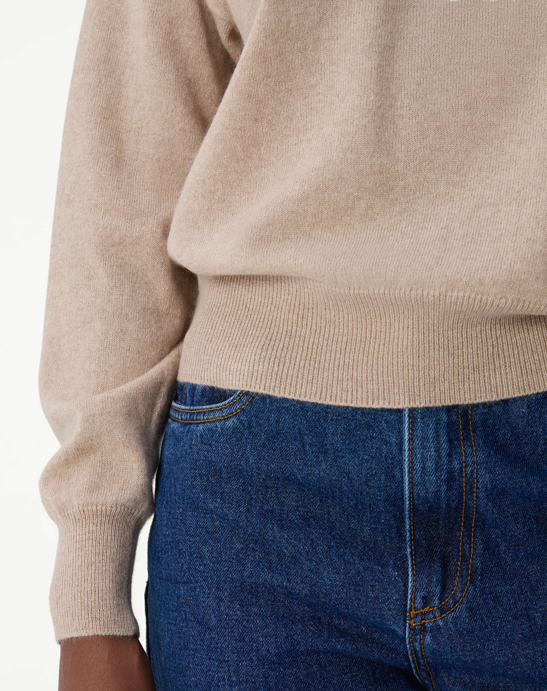 Close-up na textura suave do cashmere cáqui, destacando os detalhes finos do tricô e o aspecto aveludado do tecido.