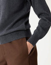 Close nos detalhes da barra e punhos do suéter de cashmere cinza mescla com textura delicada em malha.