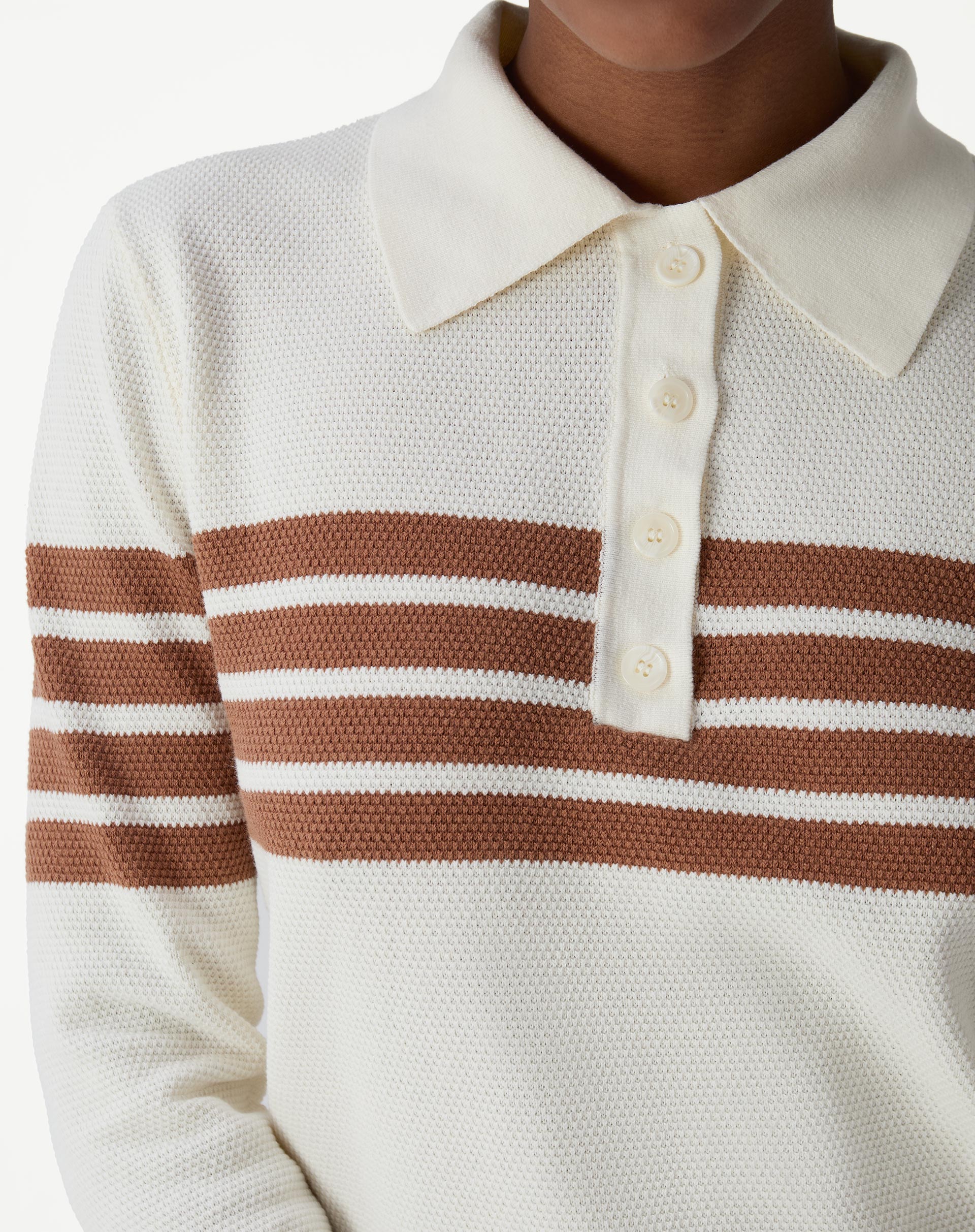 Detalhe do colarinho polo off-white e da pala com botões perolados, acabamento em tricot e costura limpa