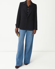 Close-up dos botões dourados ornamentais no centro da camisa preta, detalhe dos botões decorativos