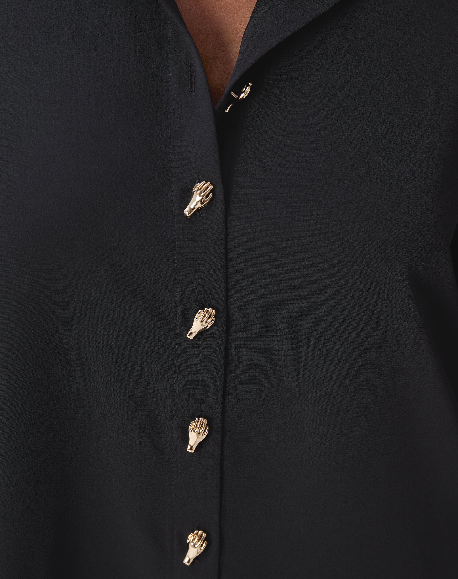 traseira da camisa preta em modelo mostrando prega central nas costas e barra arredondada alongada