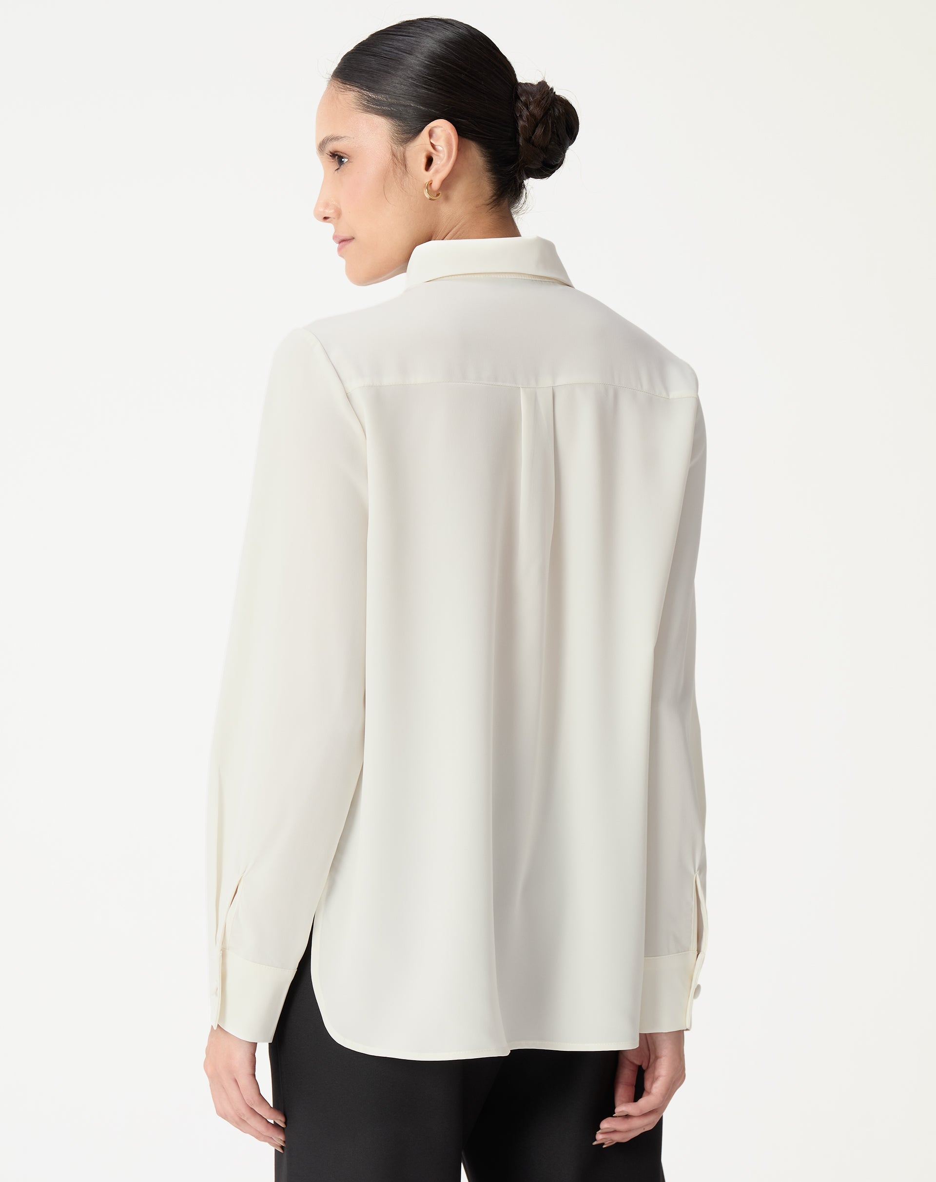 Vista traseira da camisa alongada off-white mostrando a pala com prega central e barra arredondada