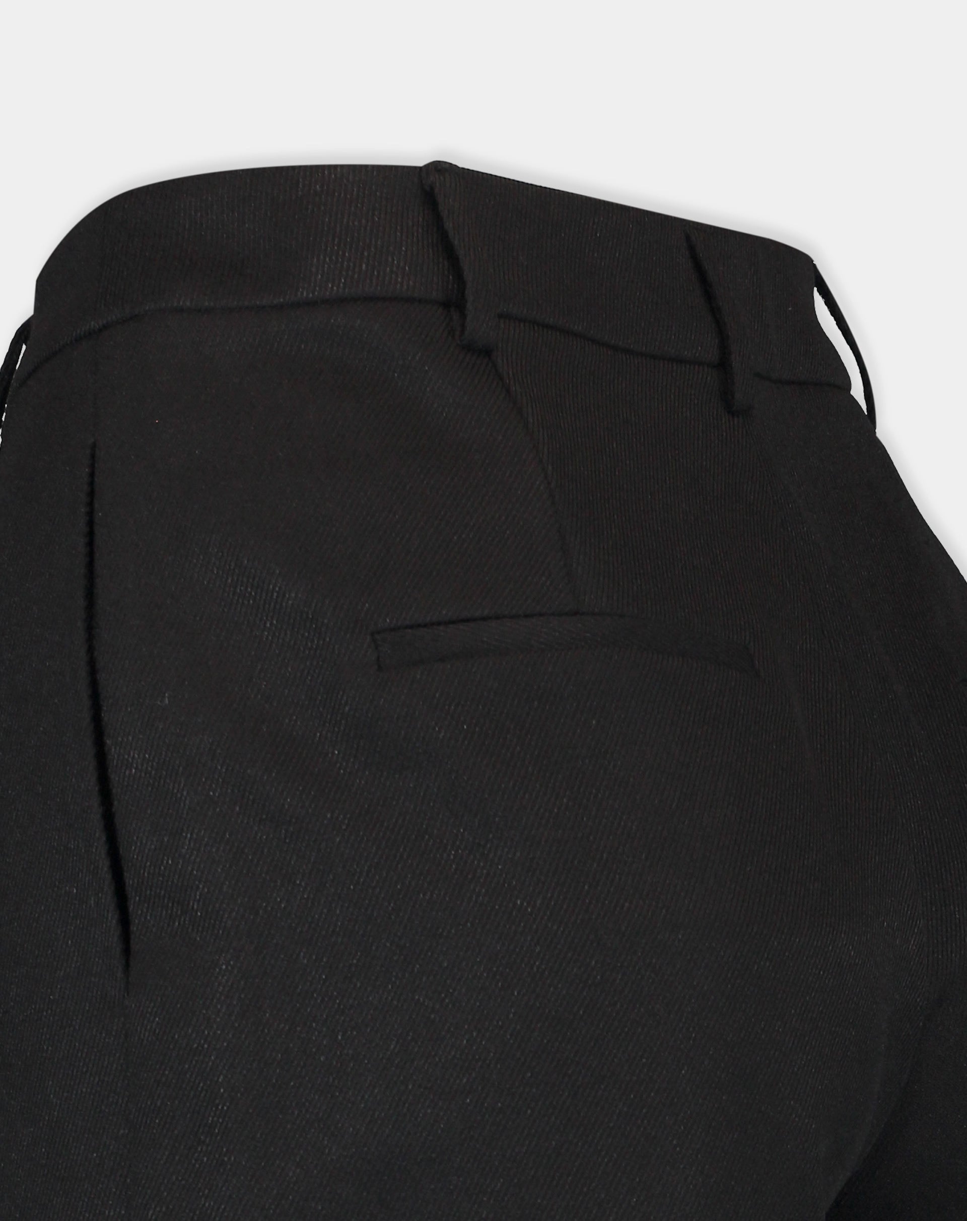 Detalhe lateral e traseiro do shorts preto mostrando bolso embutido e caimento estruturado no quadril