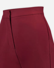 Close no cós limpo e fechamento frontal da calça alfaiataria vinho, detalhe da costura e acabamento do tecido