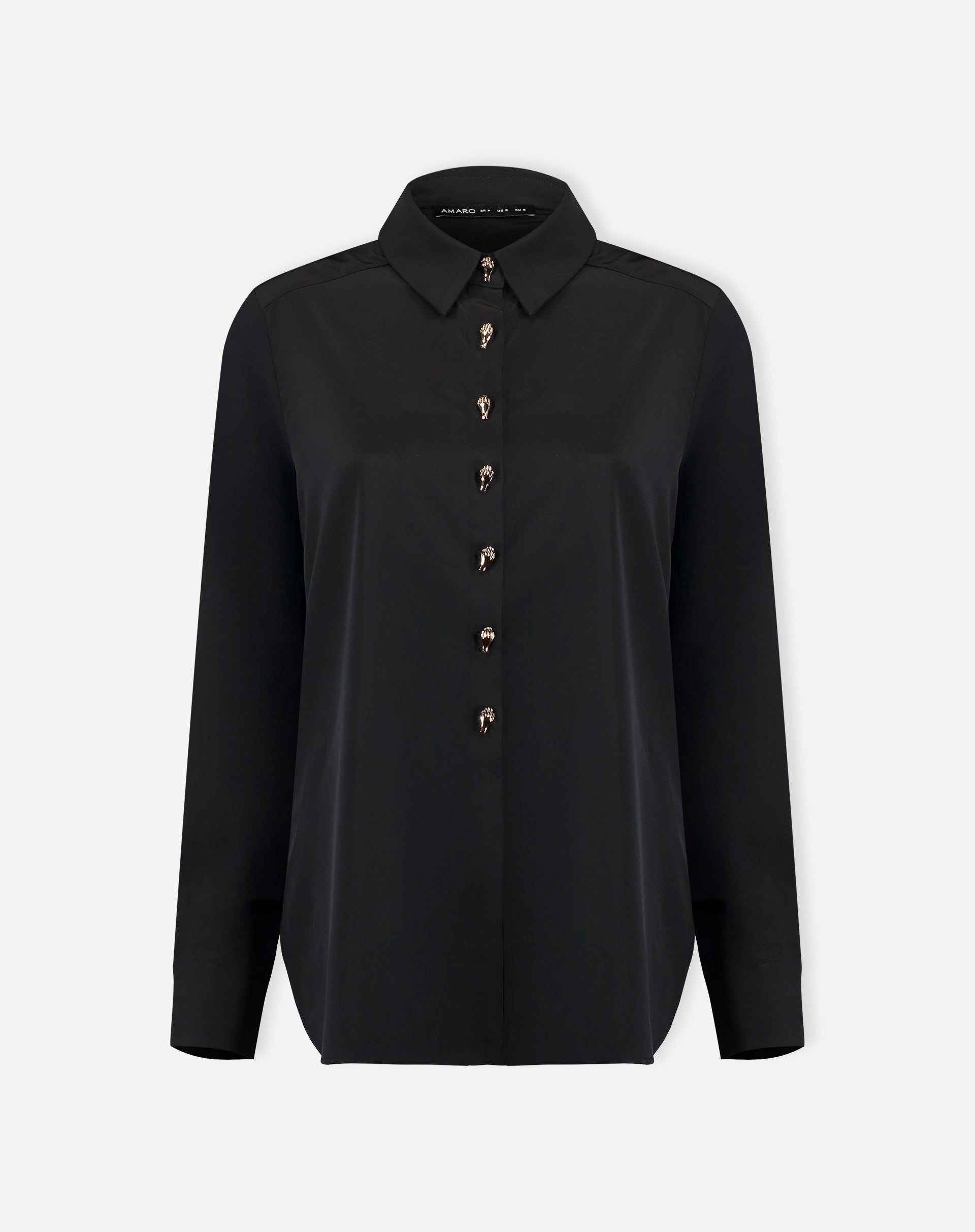 Look completo: modelo com camisa preta alongada por baixo de blazer preto e calça jeans de perna larga, proposta de styling