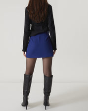 Vista traseira da saia curta reta de alfaiataria azul.