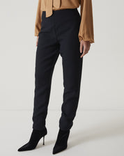 Vista lateral da calça slim preta de alfaiataria com bainha aplicada.