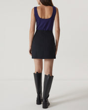 Vista traseira da saia curta de alfaiataria preta com fechamento em zíper.