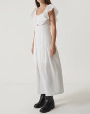 Imagem de um vestido midi off-white de tricoline com decote reto e mangas curtas, visto de lado.