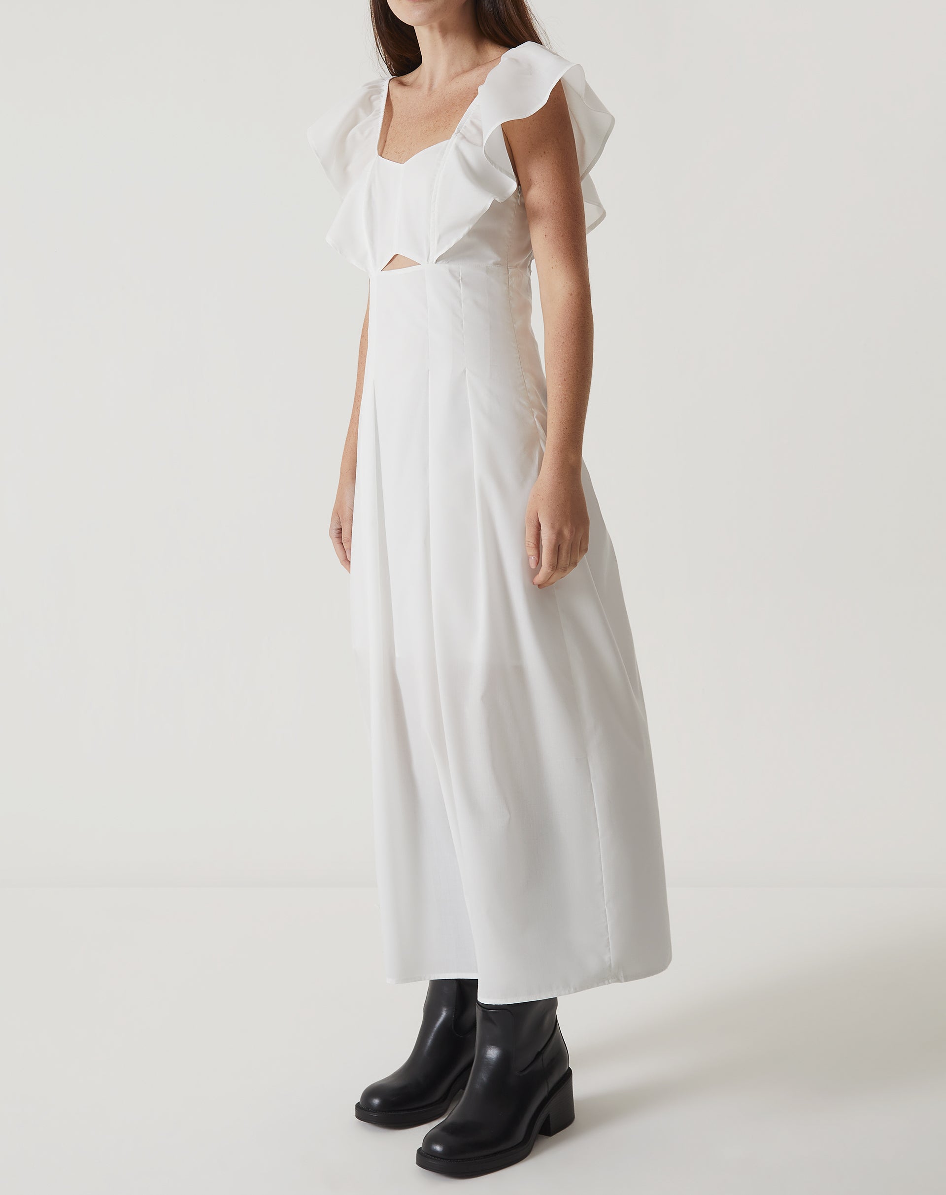 Imagem de um vestido midi off-white de tricoline com decote reto e mangas curtas, visto de lado.