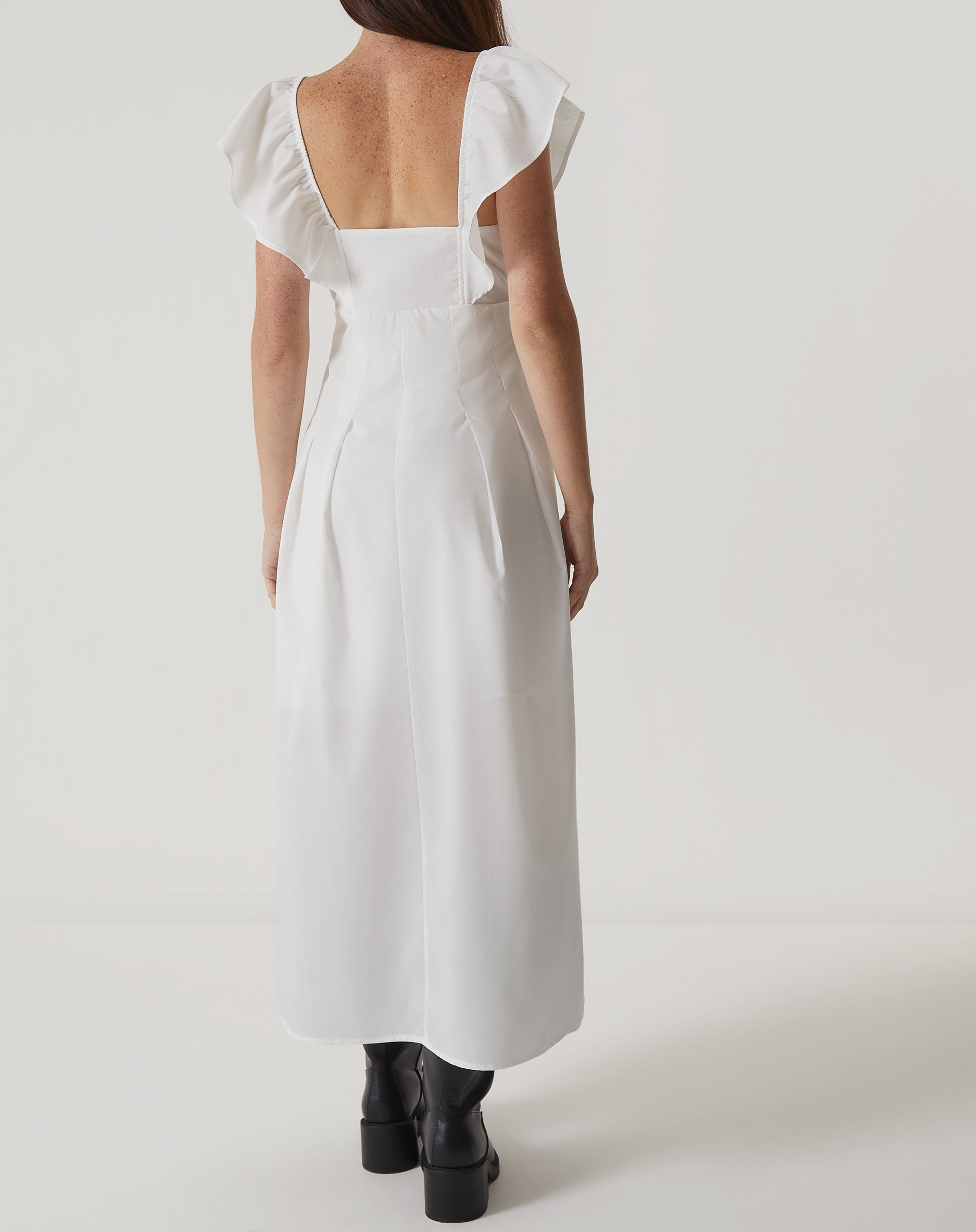 Imagem de um vestido midi off-white de tricoline com decote reto e mangas curtas, mostrando detalhes do acabamento.