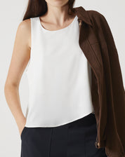 Regata off-white com babados, vista frontal com alças finas e gola redonda.